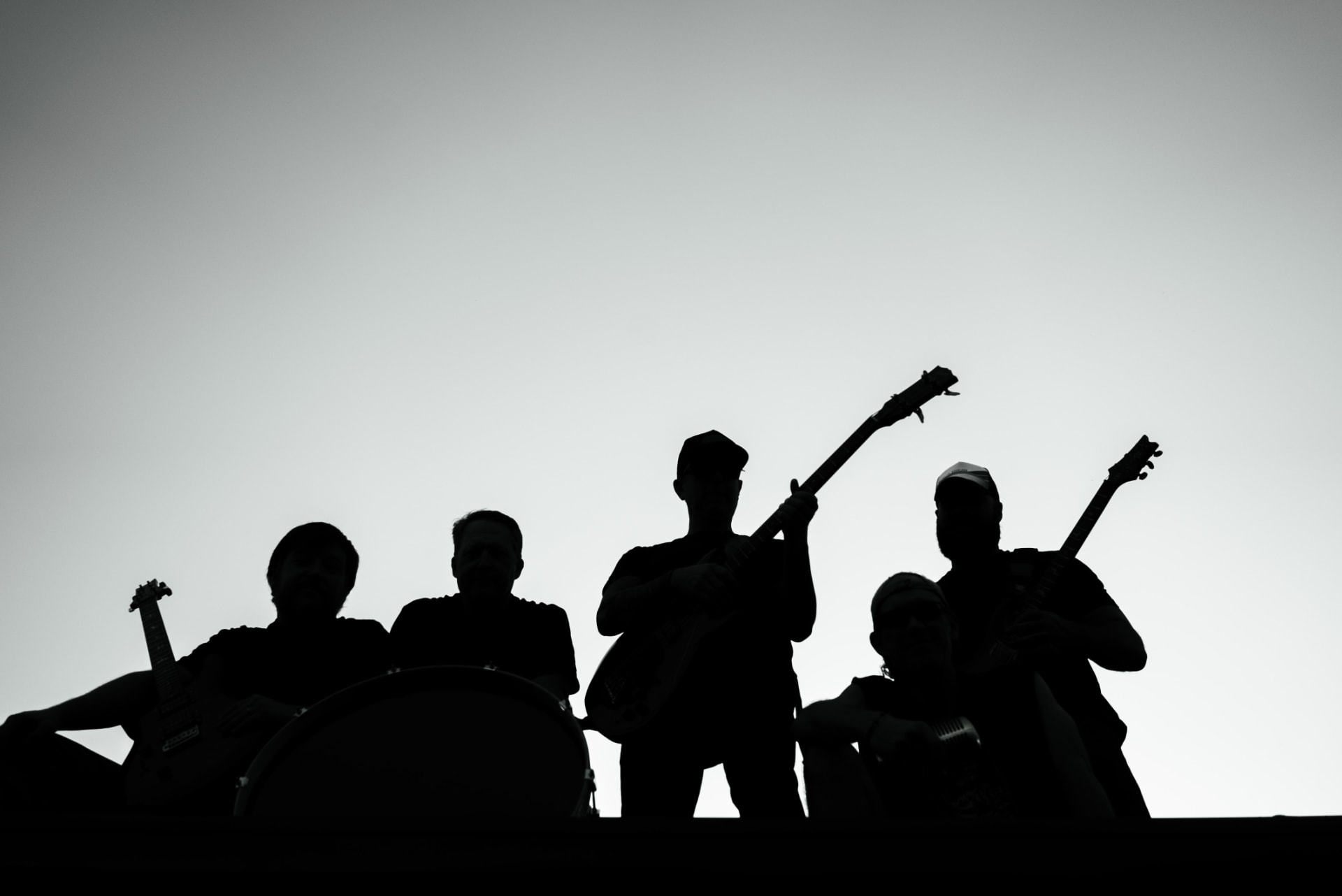 The Dusty Bunch silhouetted against a bright sky with their instruments